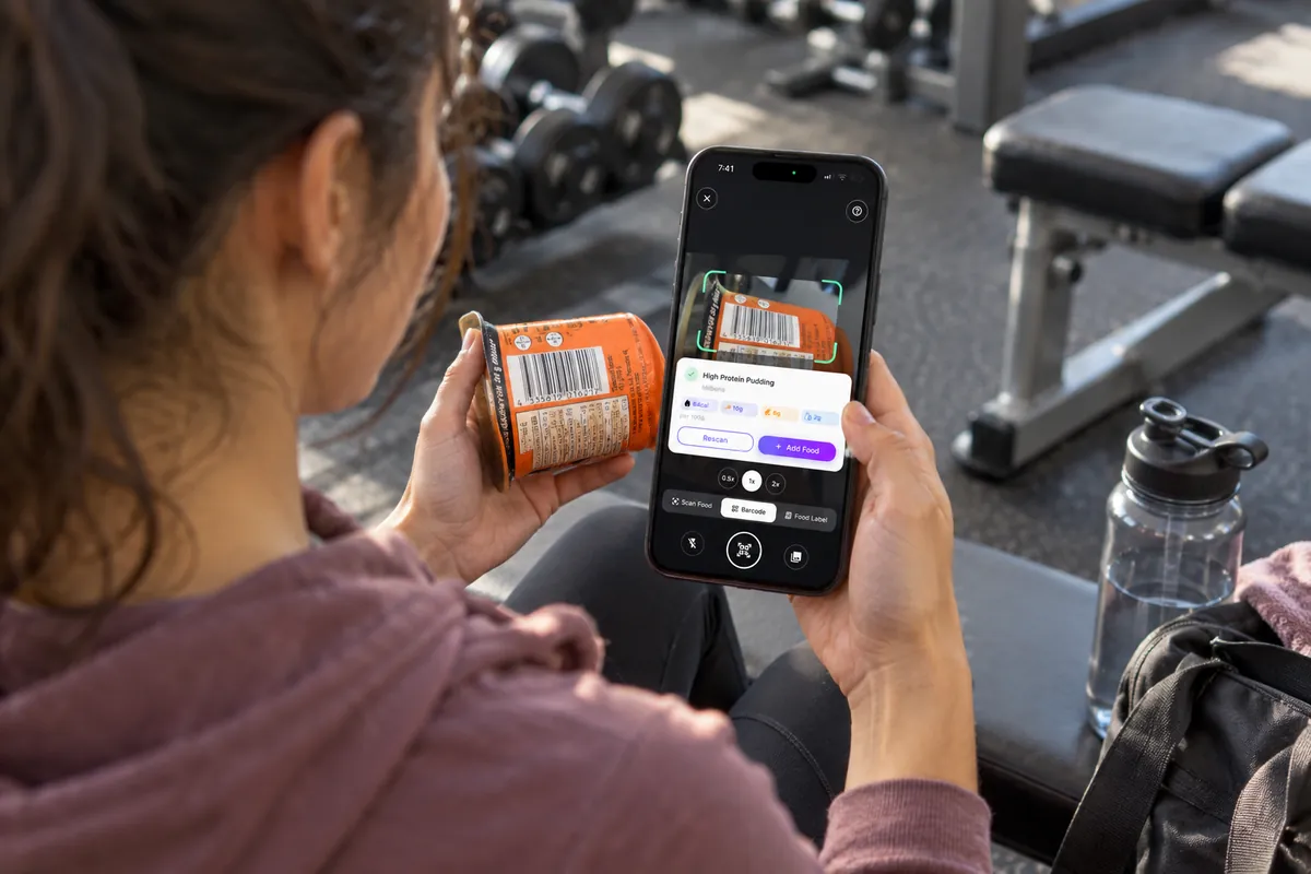 A woman at the gym scans the barcode on a protein pudding with Smart Calorie Tracker.